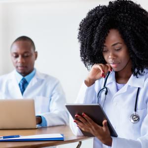 Doctors looking at tablets and laptops. 